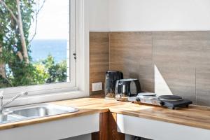 a kitchen counter with a sink and a window at Waters Edge - beachside home near Rennies Beach in Ulladulla +17 photos