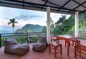 a patio with a table and chairs and a balcony at Ella Ostella in Ella
