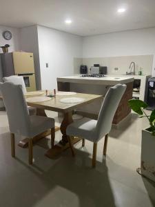 a kitchen with a wooden table and two chairs at Casa o Habitación in Villeta