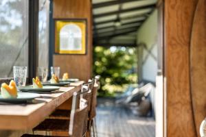 a long wooden table with plates of food on it at Ma Te Kokorou - pet-friendly Huskisson pool escape in Huskisson +22 photos