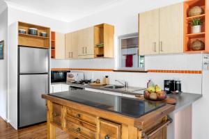 a kitchen with a wooden island in the middle at Ma Te Kokorou - pet-friendly Huskisson pool escape in Huskisson