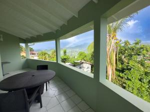 a table and chairs in a room with a window at Spacious Apartment Mountain & Sea Views in Mount Helicon