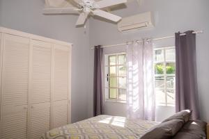 a bedroom with a bed and a ceiling fan at Spacious Apartment Mountain & Sea Views in Mount Helicon