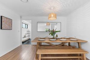 a dining room with a wooden table in a room at Collingwood - 4BR modern beachfront holiday home in Vincentia