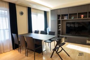 a dining room with a table and chairs and a tv at Shibuya City House 渋谷シティハウス in Tokyo