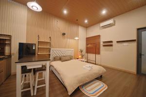 a bedroom with a bed and a desk and a television at Àla Homestay Cần Thơ in Can Tho