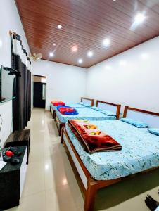 a room with three beds in a room with at New Hambala Homestay in Attigundi