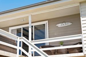 a front porch of a home with a white railing at Oceans 13 in Manyana