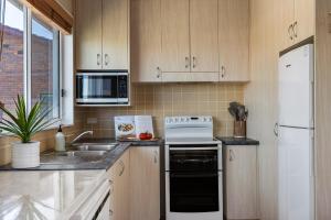 a kitchen with a sink and a white refrigerator at Oceans 13 in Manyana +29 photos