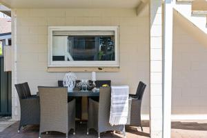 a table and chairs on a patio with a window at Oceans 13 in Manyana