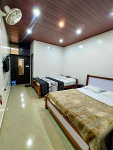 a room with two beds and a tv in it at New Hambala Homestay in Attigundi +12 photos