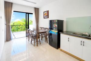 a kitchen and dining room with a table and chairs at COBI’s Home in Cam Lâm
