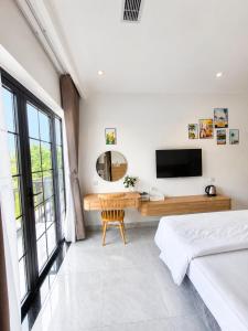 a bedroom with a desk and a television in it at COBI’s Home in Cam Lâm