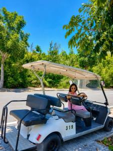a woman is sitting in a golf cart at COBI’s Home in Cam Lâm