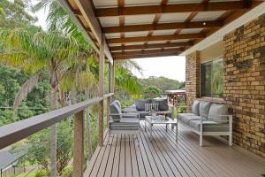 a deck with couches and chairs on a house at Simmons Sanctuary Ulladulla in Ulladulla