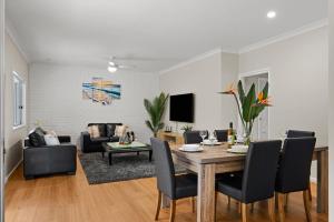 a living room with a table and chairs and a couch at Simmons Sanctuary Ulladulla in Ulladulla