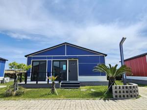 a blue house with a palm tree in front of it at Udo Chano Village in Jeju