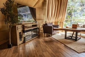 a living room with a fireplace and a table at Tropical Escape Domes in Guápiles
