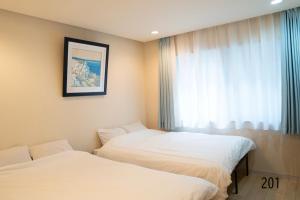 two beds in a room with a window at Shibuya City House 渋谷シティハウス in Tokyo +73 photos
