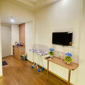 a room with a table and a tv on a wall at Greno luxe stays in Greater Noida