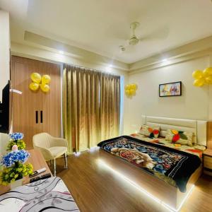 a bedroom with a bed and a table with balloons at Greno luxe stays in Greater Noida