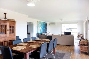 a dining room with a table and chairs at Rennies Beach Escape "Carinya" in Ulladulla