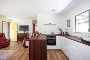 a kitchen with white cabinets and a counter top at Sandy's Beach Shack at Bawley in Bawley Point