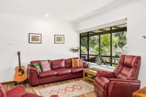 a living room with a couch and a guitar at Sandy's Beach Shack at Bawley in Bawley Point
