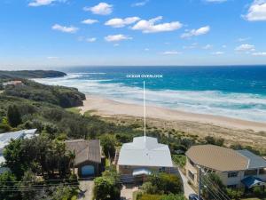 an aerial view of a beach with a building and the ocean at Ocean Overlook - Rennies Beach holiday haven in Ulladulla