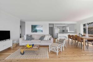 a living room with a couch and a table at Ocean Overlook - Rennies Beach holiday haven in Ulladulla