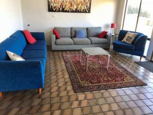 a living room with two blue couches and a table at Ocean Front on Malibu in Bawley Point