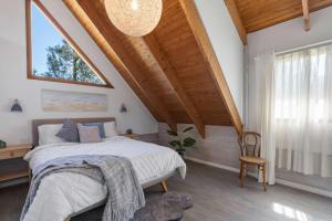 a bedroom with a bed and a large window at The Beach Haven in Bawley Point +6 photos