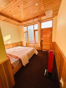 a bedroom with a bed in a room with windows at Jumanji homestay in Nagar +9 photos