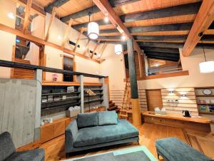 a living room with a couch and a chair at The Villa Kotoshiro -ヴィラ コトシロ- in Matsue