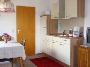 a kitchen with a table and a sink and a door at Ferienhaus im Grund in Hinterzarten