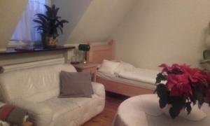 - un salon avec un canapé, un lit et une chaise dans l'établissement Willa Nestor, à Kórnik