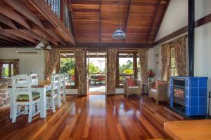 a living room with wooden ceilings and a table and chairs at Stone Cottage - vineyard estate w. fireplace in Milton