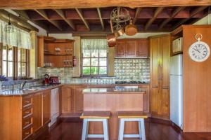 a kitchen with wooden cabinets and a clock on the wall at Stone Cottage - vineyard estate w. fireplace in Milton