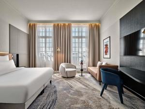 a hotel room with a bed and a desk at Mövenpick Grand Hotel Wroclaw in Wrocław