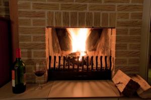 a fireplace with a bottle of wine and a glass at Ferienhaus Sonnenschein in Sint Maarten