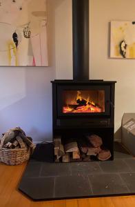 a black stove with a fire in a room at Murramarang Haven in Bawley Point