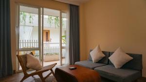 a living room with a couch and a balcony at The Rivavi Legian in Legian