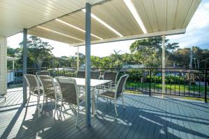 a patio with a table and chairs on a deck at MeNo's at Bawley in Bawley Point