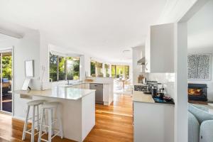 a kitchen with white appliances and a living room at Point Break in Bawley Point