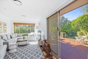 a living room with a large sliding glass door at Point Break in Bawley Point
