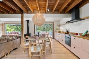 a kitchen with a table and chairs and a couch at Coastal Soul in Narrawallee
