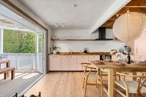 a kitchen with a wooden table and a large window at Coastal Soul in Narrawallee