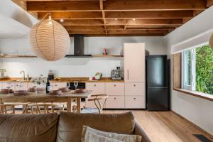 a kitchen and dining room with a table and a black refrigerator at Coastal Soul in Narrawallee +42 photos