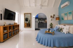 a bedroom with a large bed with a blue blanket at Deja Blue - Comfortable Beachfront condo in Marigot