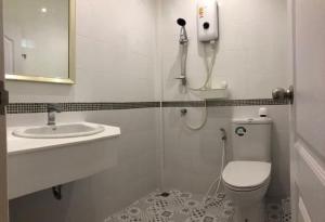 a bathroom with a shower and a toilet and a sink at Homestay Laksi in Lak Si
